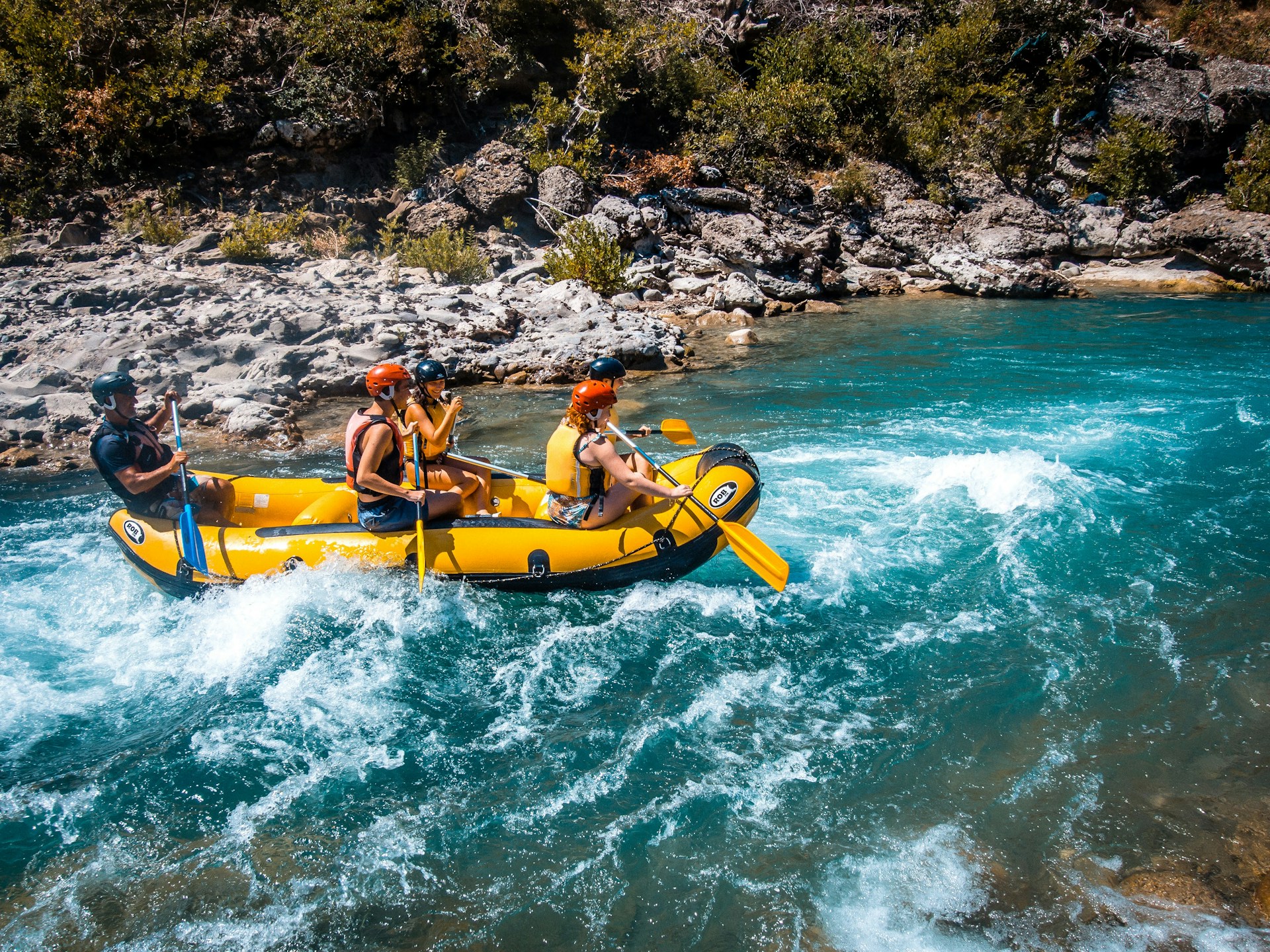 A group of people riding on the back of a raft A group of people riding on the back of a raft