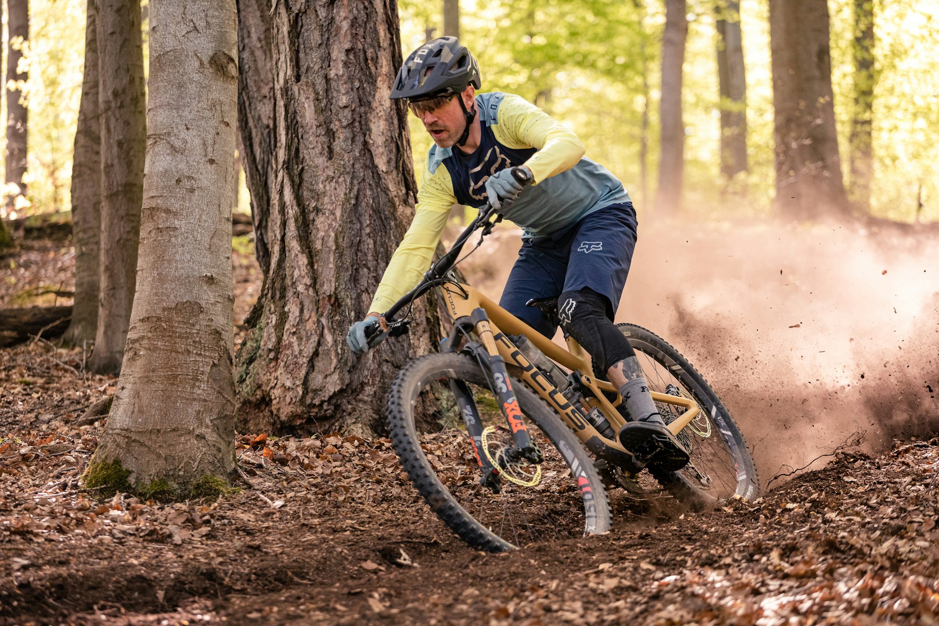 A man riding a mountain bike through a forest A man riding a mountain bike through a forest