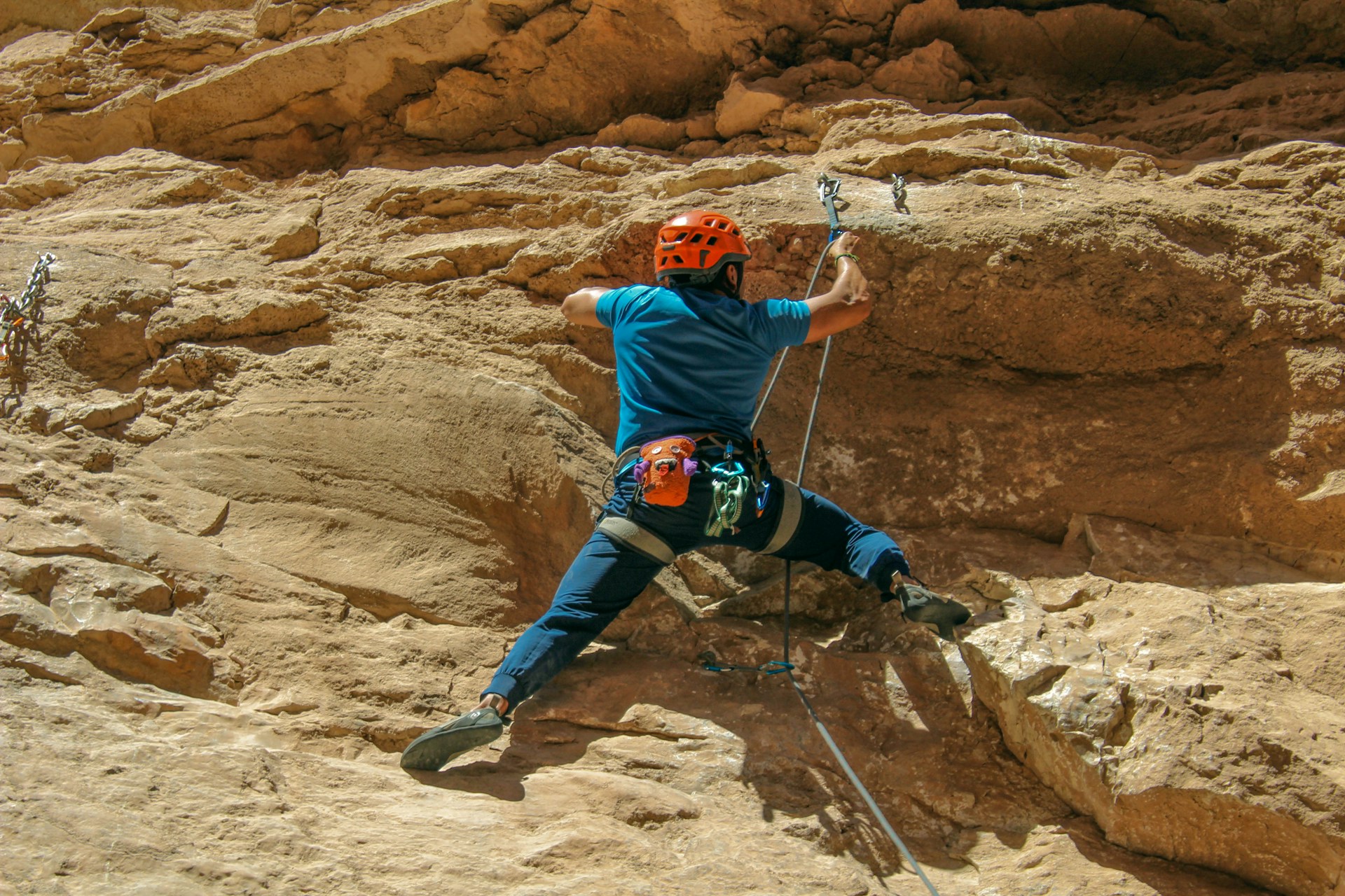 A man climbing up the side of a mountain A man climbing up the side of a mountain